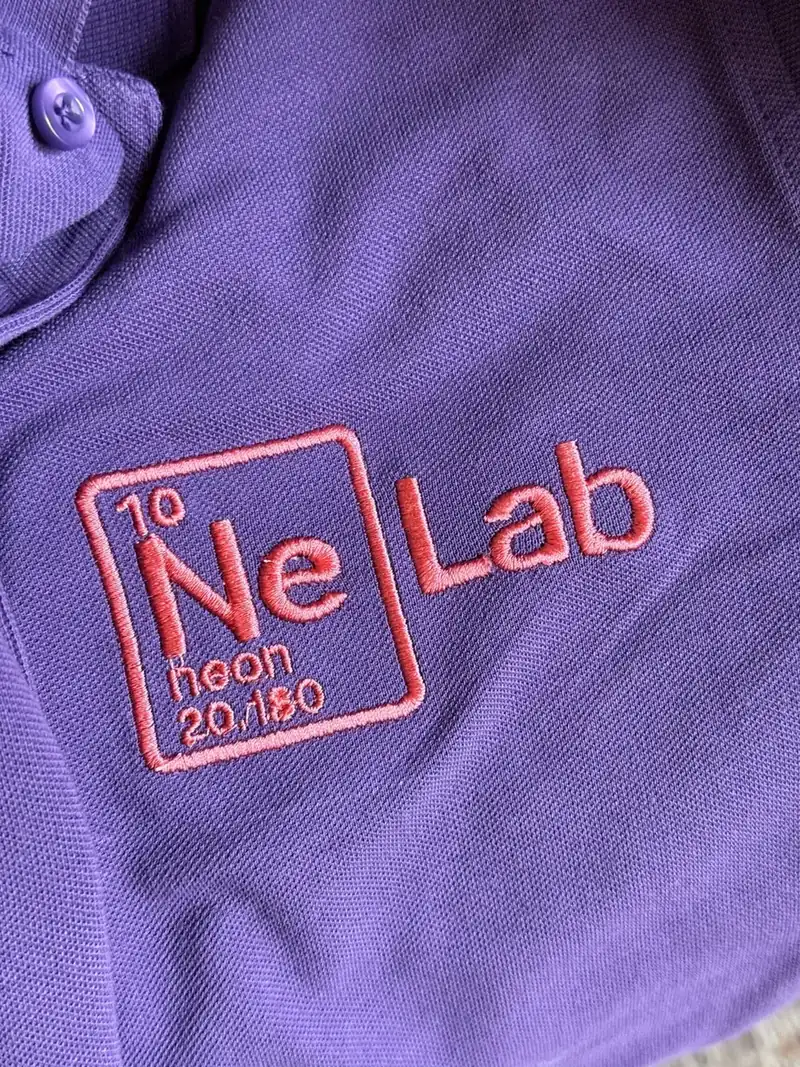 Sigla NeonLab brodată pe tricoul echipei