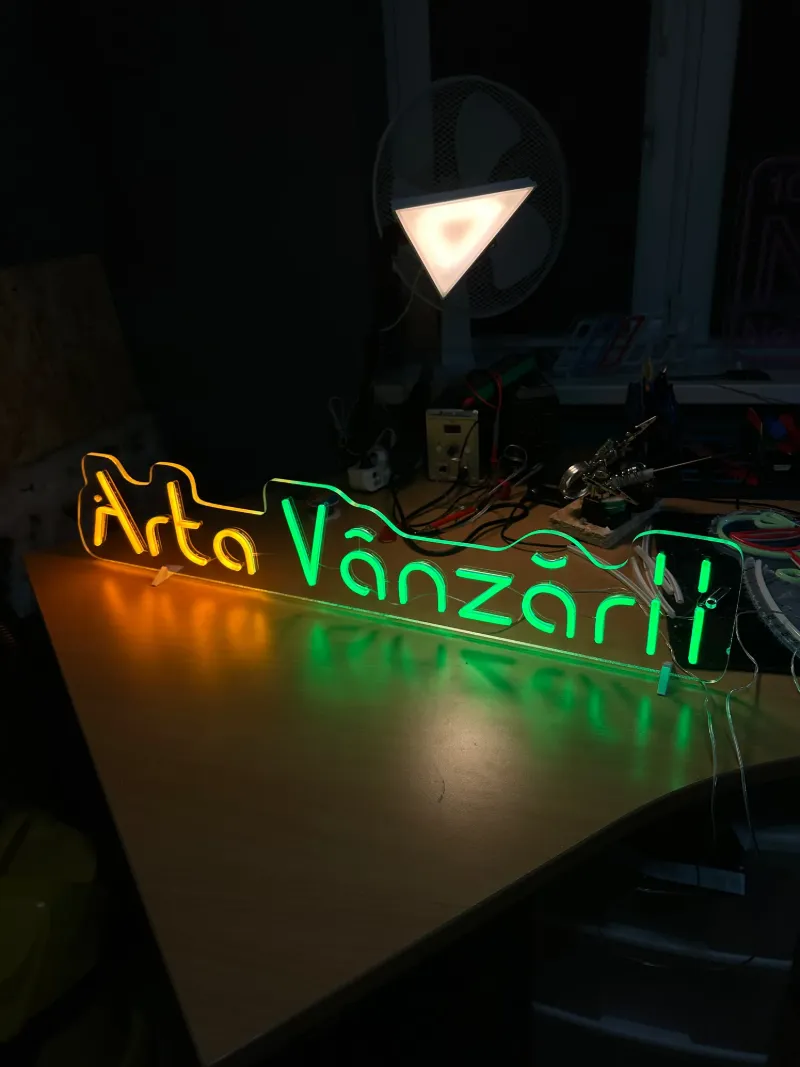 Semn neon LED portocaliu și verde cu textul Arta Vânzării