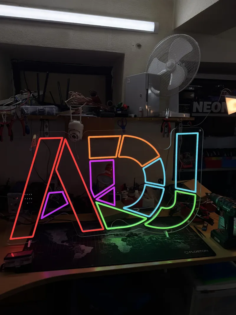 Semn neon LED cu literele ADJ, în roșu, mov, portocaliu, verde și albastru